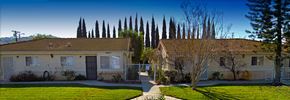 Orange apartment for rent - a house with a yard and trees in front of it