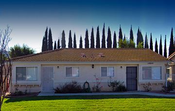 Orange apartment for rent - a white house with trees in the background