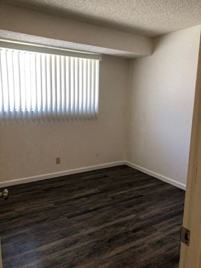 Modesto apartment for rent - an empty room with a window and wooden floors