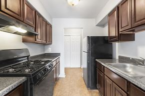 Atlantic City apartment for rent - a kitchen with wood cabinets and black appliances and a black refrigerator
