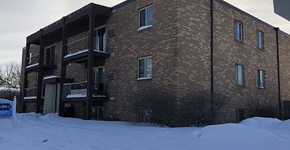 West Fargo apartment for rent - A brick building with a balcony and snow on the ground.
