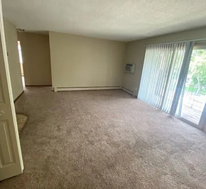 West Fargo apartment for rent - A room with carpeted floor and a window with blinds.