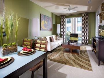 La Mesa apartment for rent - A living room with a white couch, a coffee table, and a dining table with chairs.
