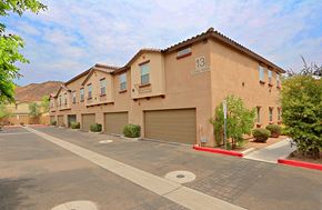 Glendale townhouse for rent - a beige apartment building with a parking lot and garages