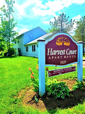 Williamson apartment for rent - a sign for the harvest court apartments in front of a house