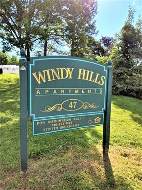 Clyde apartment for rent - a sign for windy hills apartments in a park
