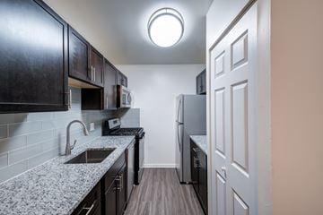 Alexandria apartment for rent - A kitchen with black cabinets and a granite countertop.
