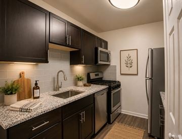 Alexandria apartment for rent - A kitchen with dark brown cabinets and a granite countertop.