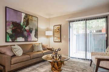 Citrus Heights apartment for rent - A living room with a brown couch, a glass coffee table, and a painting on the wall.