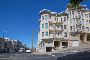 San Francisco apartment for rent - A street view of a residential area with apartment buildings and parked cars.