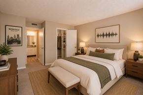 Nashville apartment for rent - A bedroom with a bed, nightstand, and a poster on the wall.