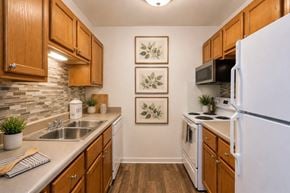 Hermitage apartment for rent - A kitchen with wooden cabinets and a white refrigerator.