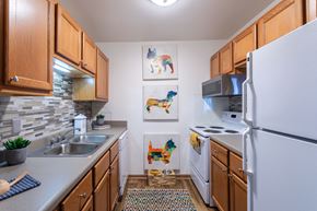 Hermitage apartment for rent - a kitchen with white appliances and wooden cabinets