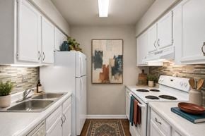 Nashville townhouse for rent - A kitchen with white cabinets and a white stove top oven.