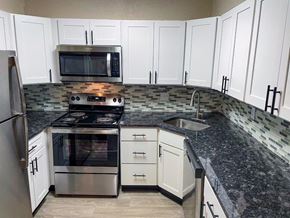 Nashville apartment for rent - A kitchen with white cabinets and a black stove top.