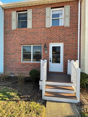 Smithfield apartment for rent - A red brick house with a white door and steps leading to it.