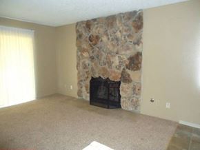 Modesto house for rent - A stone fireplace in a room with a carpeted floor.