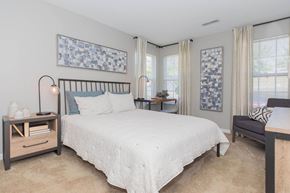 Presto apartment for rent - A bedroom with a large bed and a nightstand with a lamp.