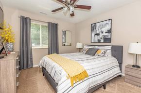 Loveland apartment for rent - a bedroom with a bed and a ceiling fan