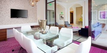 San Diego apartment for rent - A modern living room with a glass table and white chairs.