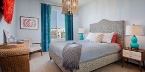 San Diego apartment for rent - A bedroom with a large bed and a chandelier.