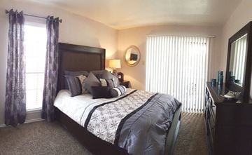 Corpus Christi apartment for rent - A bedroom with a large bed and a window with curtains.