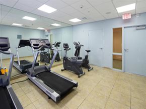 Miami apartment for rent - a gym with several machines and a exit door