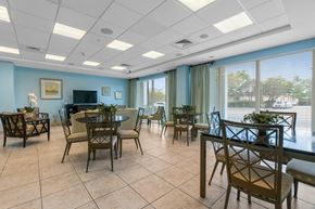 Miami apartment for rent - a dining room with tables and chairs and a piano