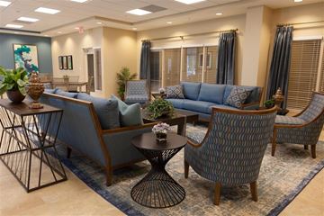 Miami apartment for rent - a living room with blue couches and chairs and a table