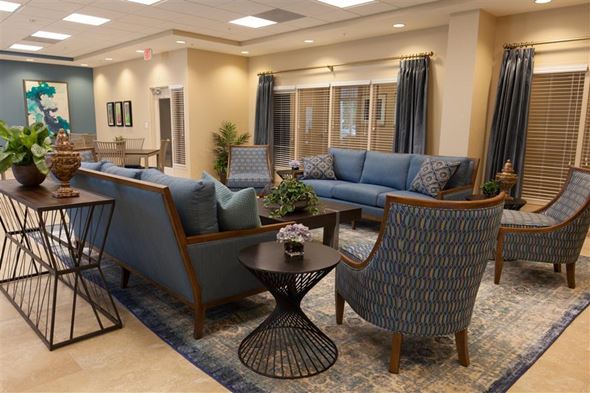Miami apartment for rent - a living room with blue couches and chairs and a table