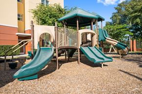 Miami apartment for rent - a playground with two slides and a swing set