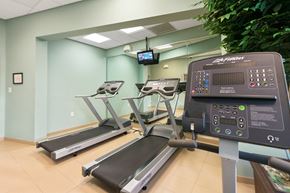 Naranja apartment for rent - a gym with treadmills and a tv in the corner of a room