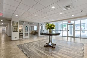 Miami apartment for rent - a large lobby with a table in the middle of it