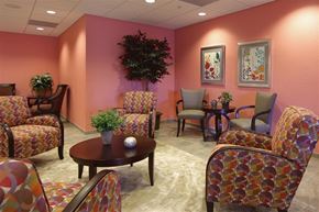 Miami apartment for rent - a lobby with chairs and tables and a pink wall
