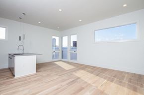New Orleans apartment for rent - an empty living room with a kitchen and a door to a balcony