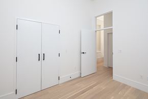 New Orleans apartment for rent - a row of white closets in a room with a wood floor