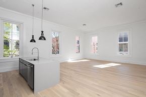 New Orleans apartment for rent - an open kitchen and living room with white walls and wood floors