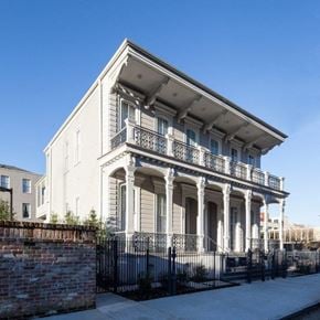 New Orleans apartment for rent - A white two-story building with a balcony and a black fence.