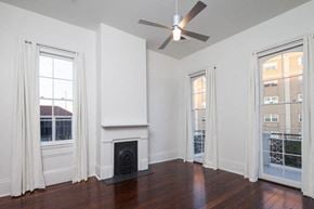 New Orleans apartment for rent - A room with a fireplace and a ceiling fan.