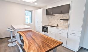 Brandon apartment for rent - a kitchen with a wooden table and white cabinets