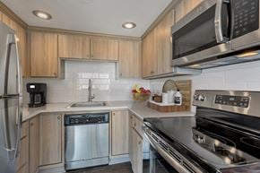 Denver apartment for rent - a kitchen with stainless steel appliances and wooden cabinets
