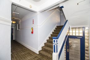 San Francisco apartment for rent - A staircase with a blue railing and a red fire extinguisher on the wall.