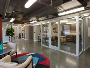 Washington apartment for rent - A modern office space with glass walls and a colorful rug on the floor.