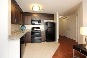 Washington apartment for rent - A kitchen with black appliances and brown cabinets.