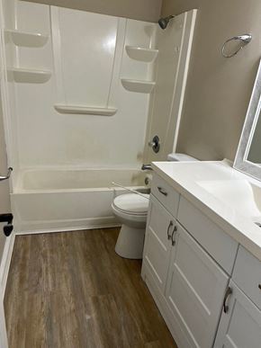 Smithfield apartment for rent - A white bathroom with wood flooring and a white tub.