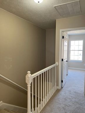 Smithfield apartment for rent - A white railing in a hallway with a tan wall.