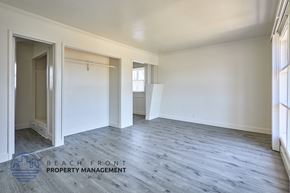 Compton apartment for rent - A spacious room with wooden flooring and white walls, with a doorway leading to another room.
