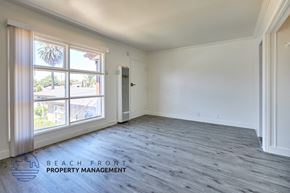 Compton apartment for rent - A spacious room with a view of the beach through the windows.