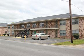 Pascagoula apartment for rent - a car parked in front of a brick apartment building