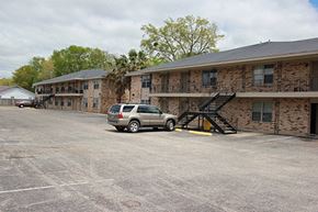 Pascagoula apartment for rent - a parking lot with a car in front of a building